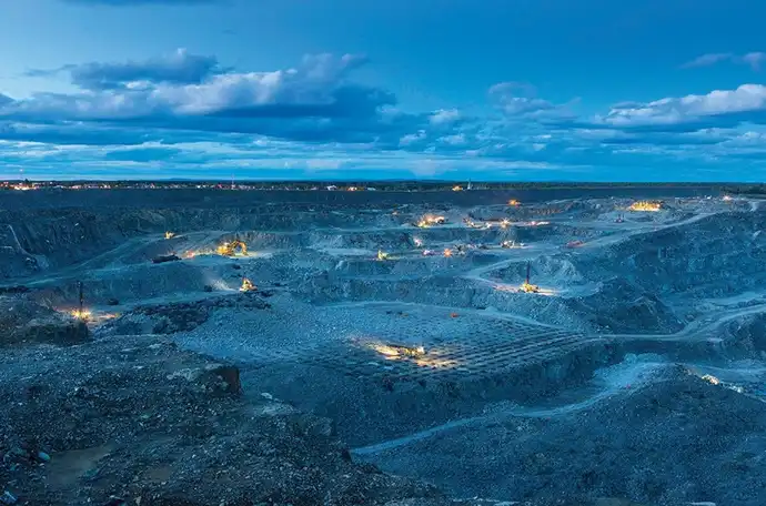 A mining site at night under a blue sky