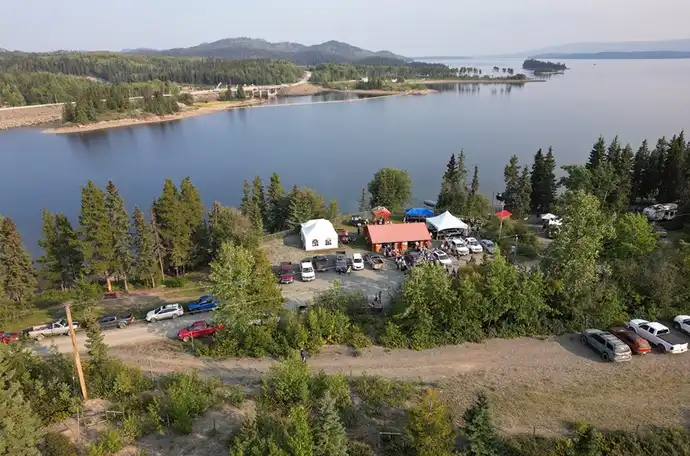 An aerial photo of pavilions set up by a wooded riverside